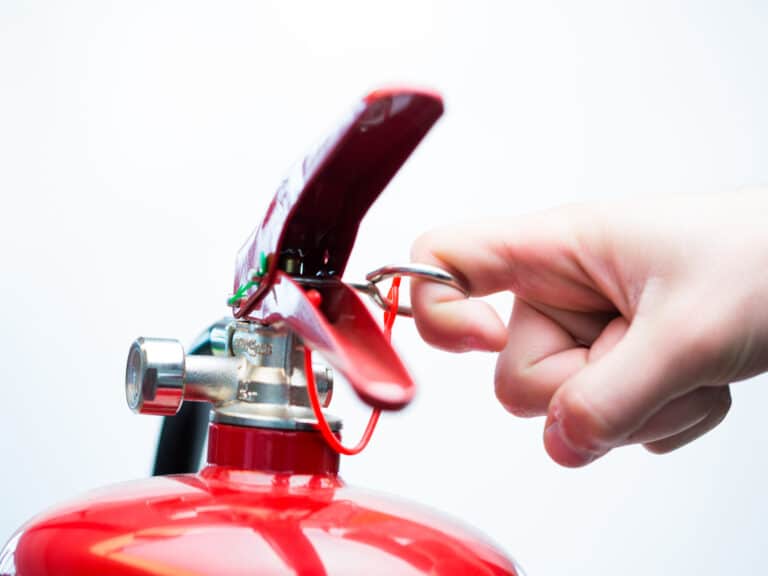 Hand,Pulling,Pin,Of,Fire,Extinguisher